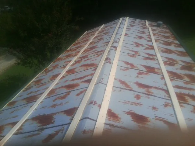 Rusted metal roof panels with new wood purlins before replacement — Storm Damage Roof Repair in Yukon by Roofing Brothers
