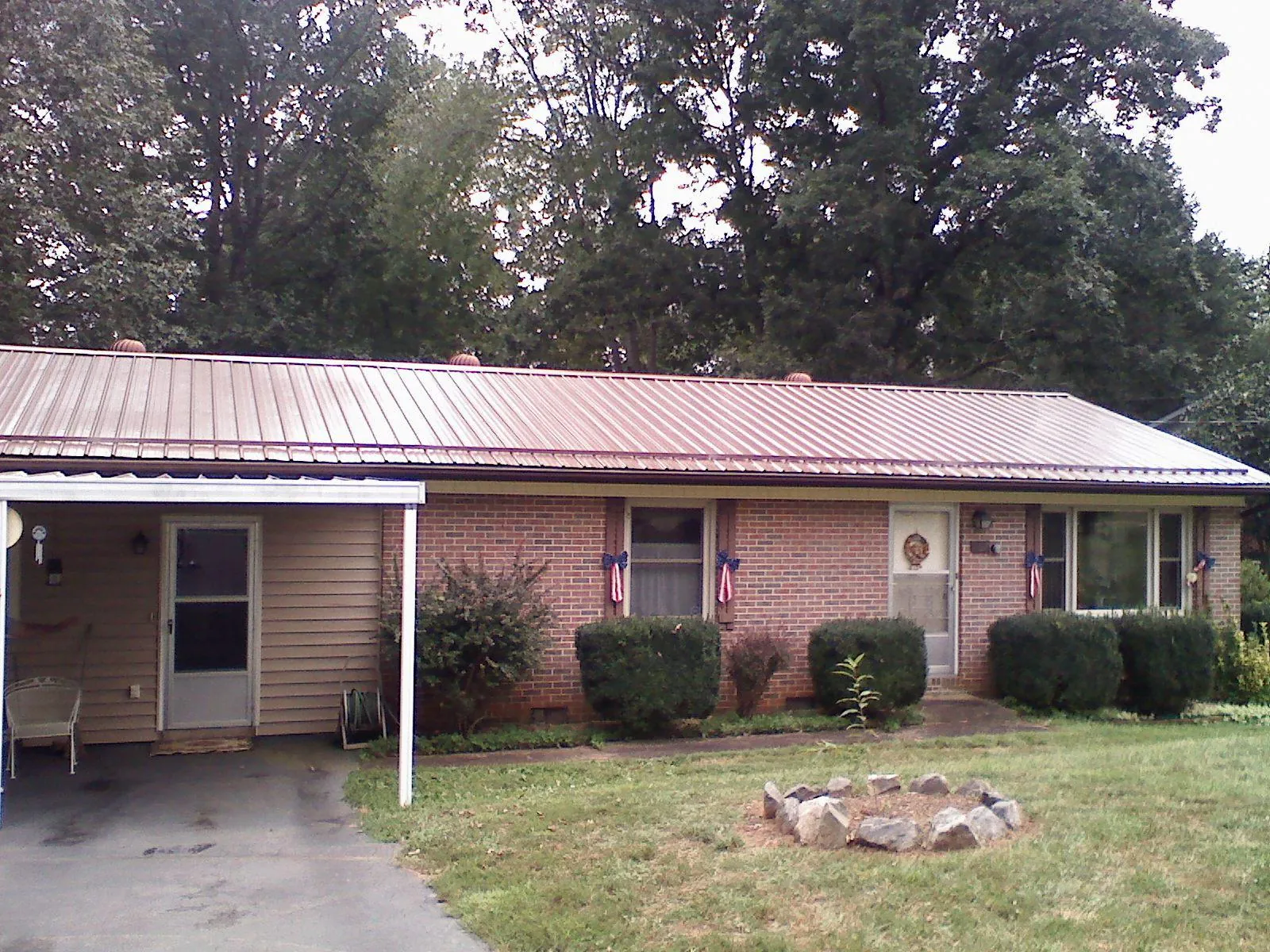 Bronze metal roof and carport on a brick ranch home — Roof Repair work by our crew in Yukon