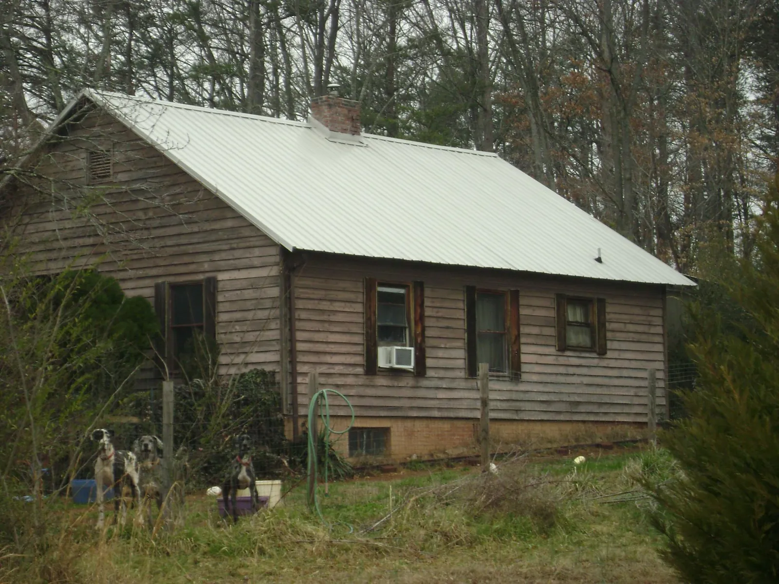 White metal roof on an old wood sided farmhouse, from a Metal Roof Installation job in Yukon